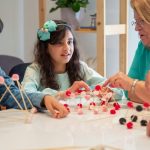 Grandmother playing educational games with grandchildren indoors, fostering creativity and learning.